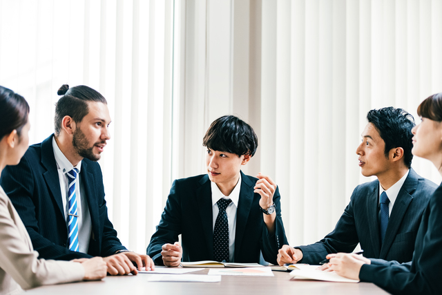 ミーティングで男性が意見を述べているイメージ