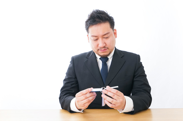 単語帳で英単語を覚える男性